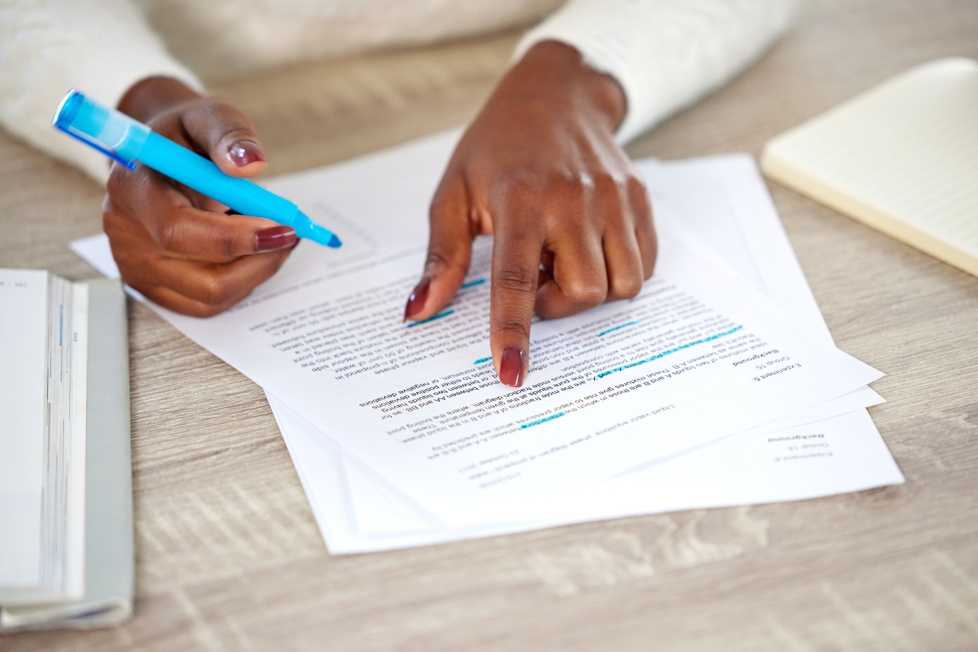 Shot of an unrecognisable woman making notes while studying at home Shot of an unrecognisable woman making notes while studying at home